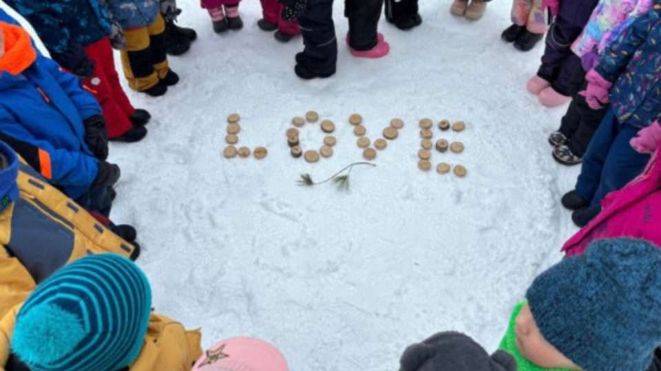 OCSB students outdoors with the word love made out of wood pallets