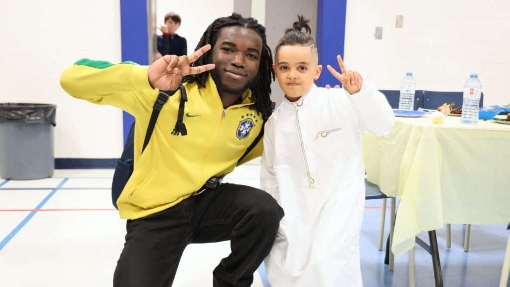 a youth and a younger boy smiling