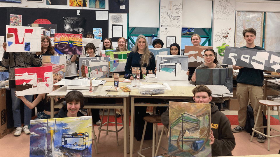 Students and teacher holding their art work for the Art with Heart Project