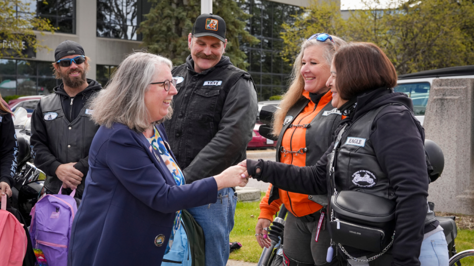 Mary Donaghy greets the Motorcycle team members