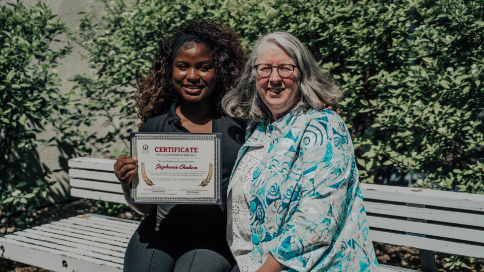 Stephanie holding her certificate beside Mary